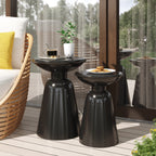 Two black side tables on a wooden deck with a chair and plant in the background.