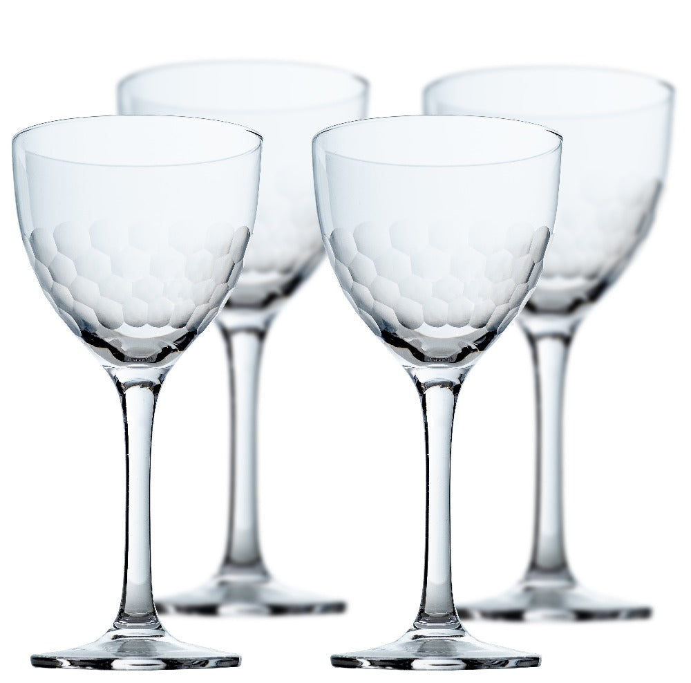 Set of four clear wine cocktail glasses with textured design on a white background