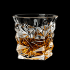 Crystal glass filled with amber liquid on a black background