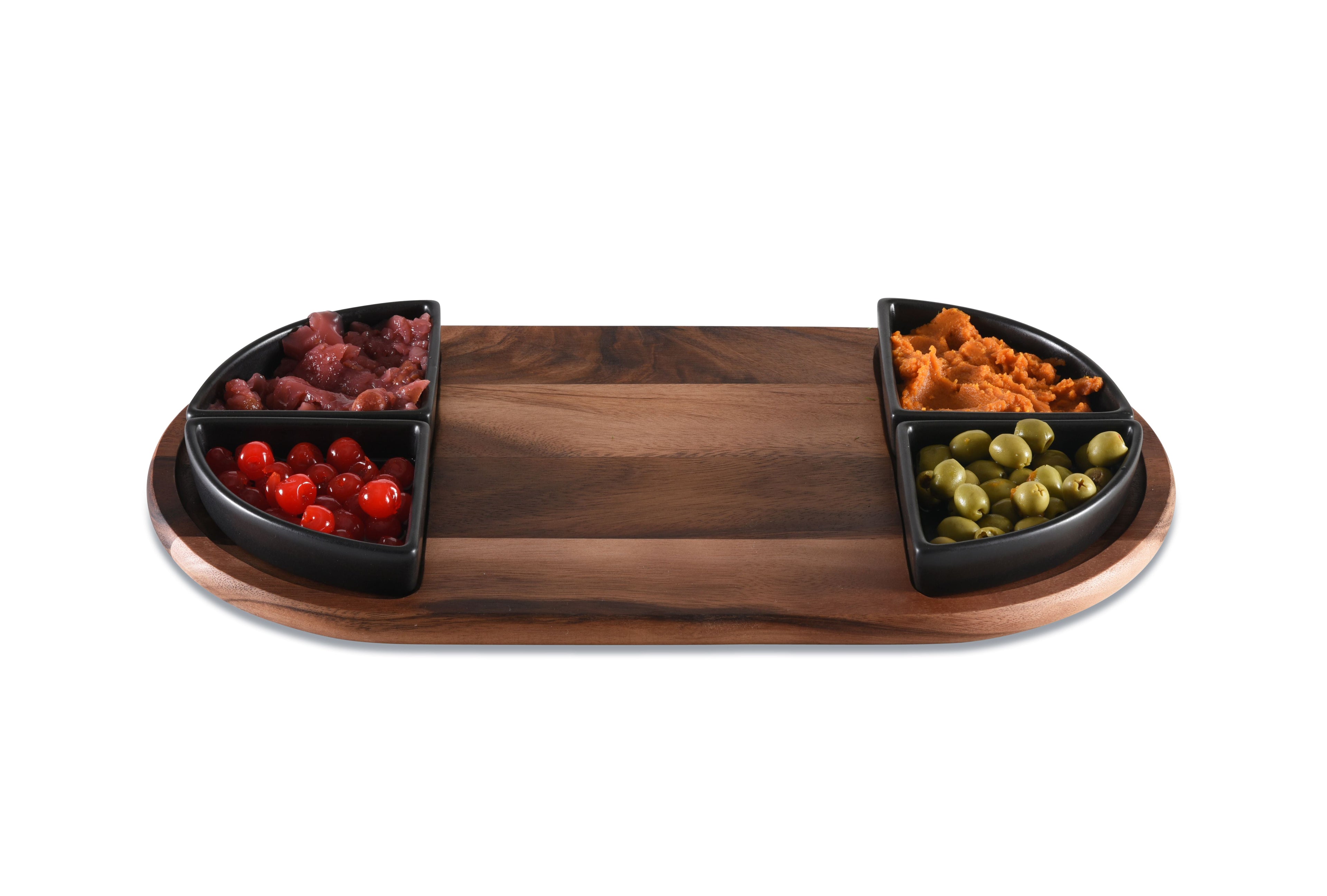 Wooden charcuterie board with black compartments filled with various meats and cheeses on a white background