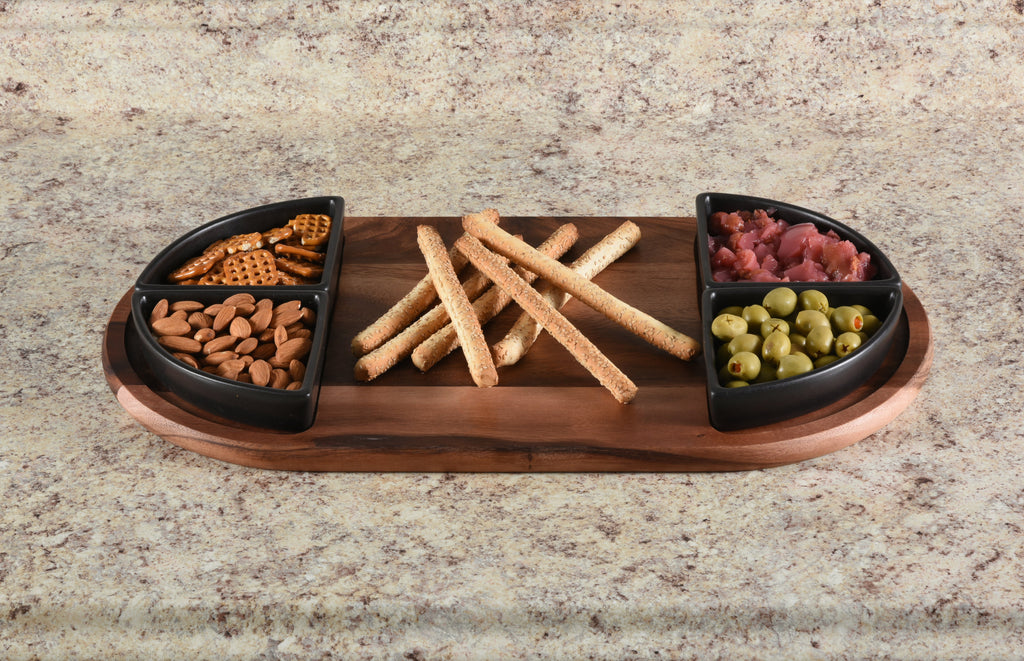 Wooden snack platter with compartments filled with snacks on a granite countertop.