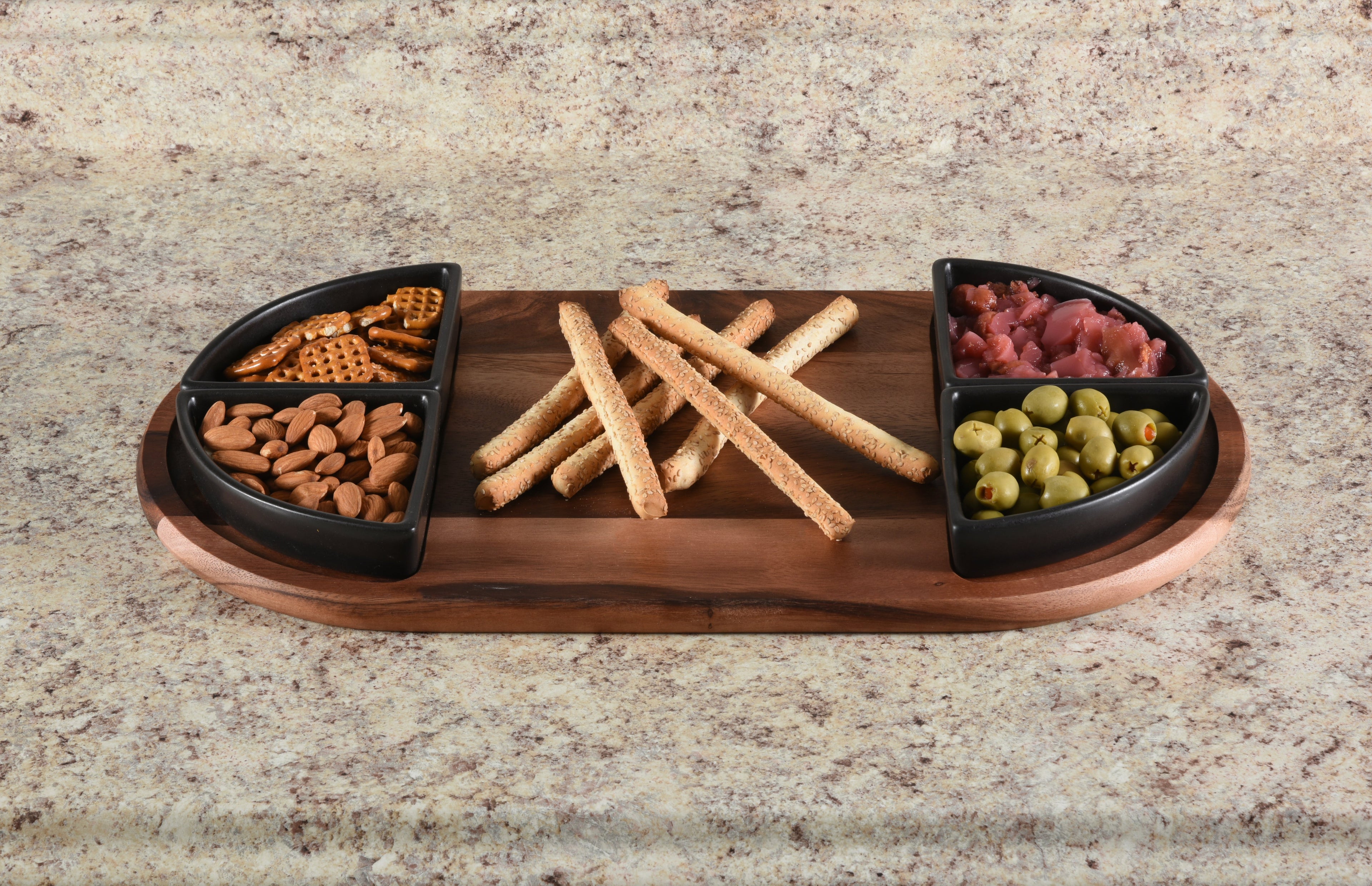 Wooden snack platter with compartments filled with snacks on a granite countertop.