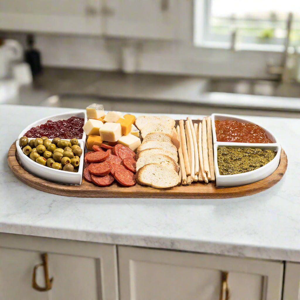 Wooden charcuterie board with assorted foods on a kitchen counter