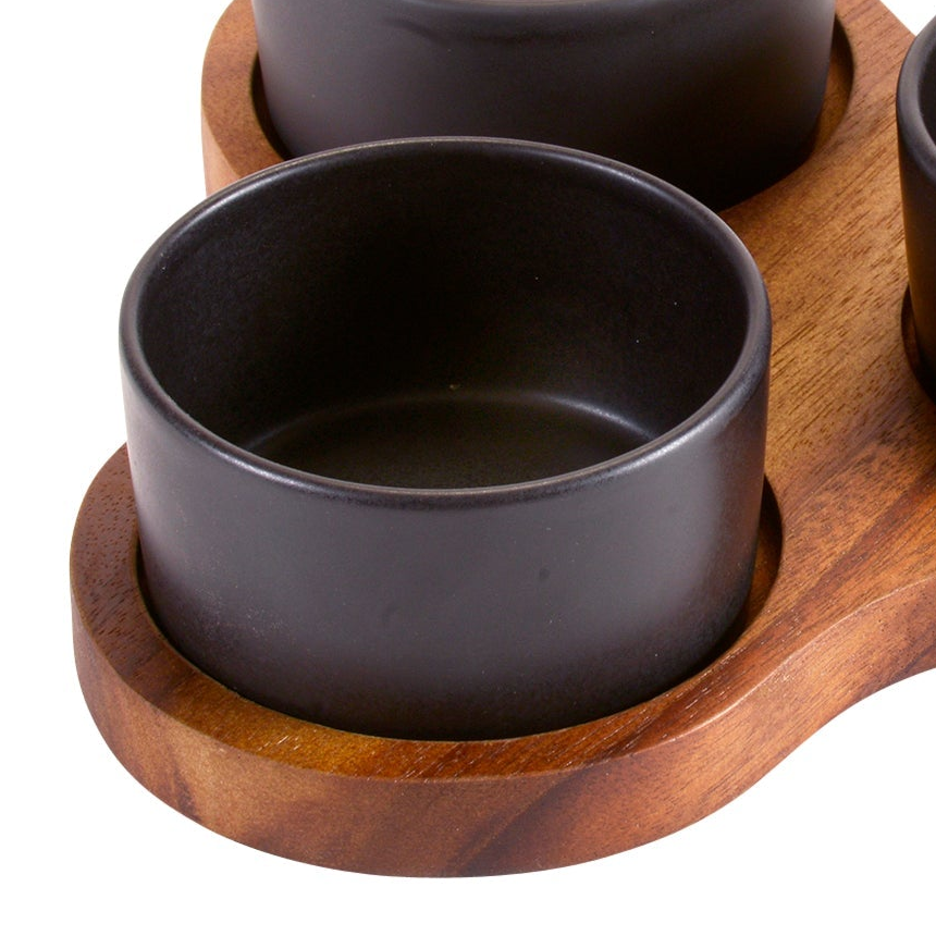 Black ceramic cups on a wooden tray