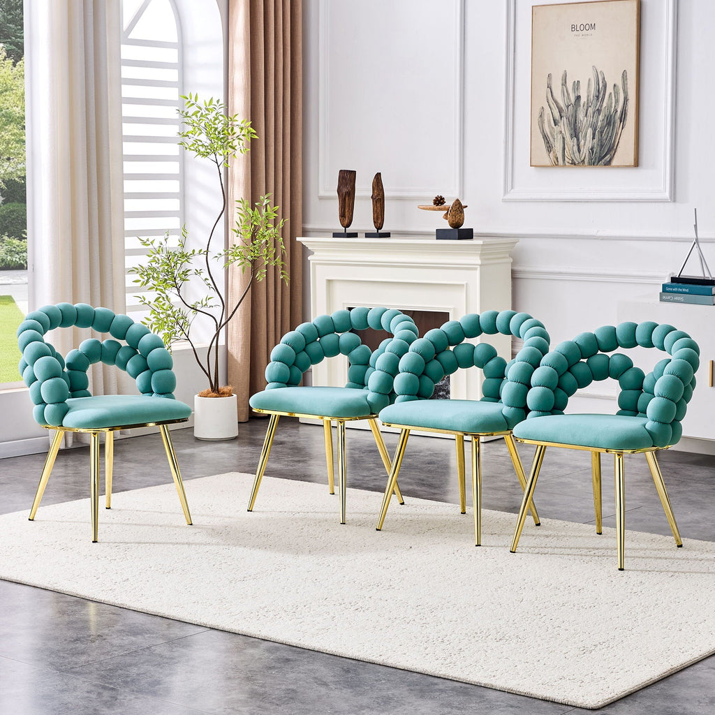 Set of four teal chairs with gold legs in a living room setting.
