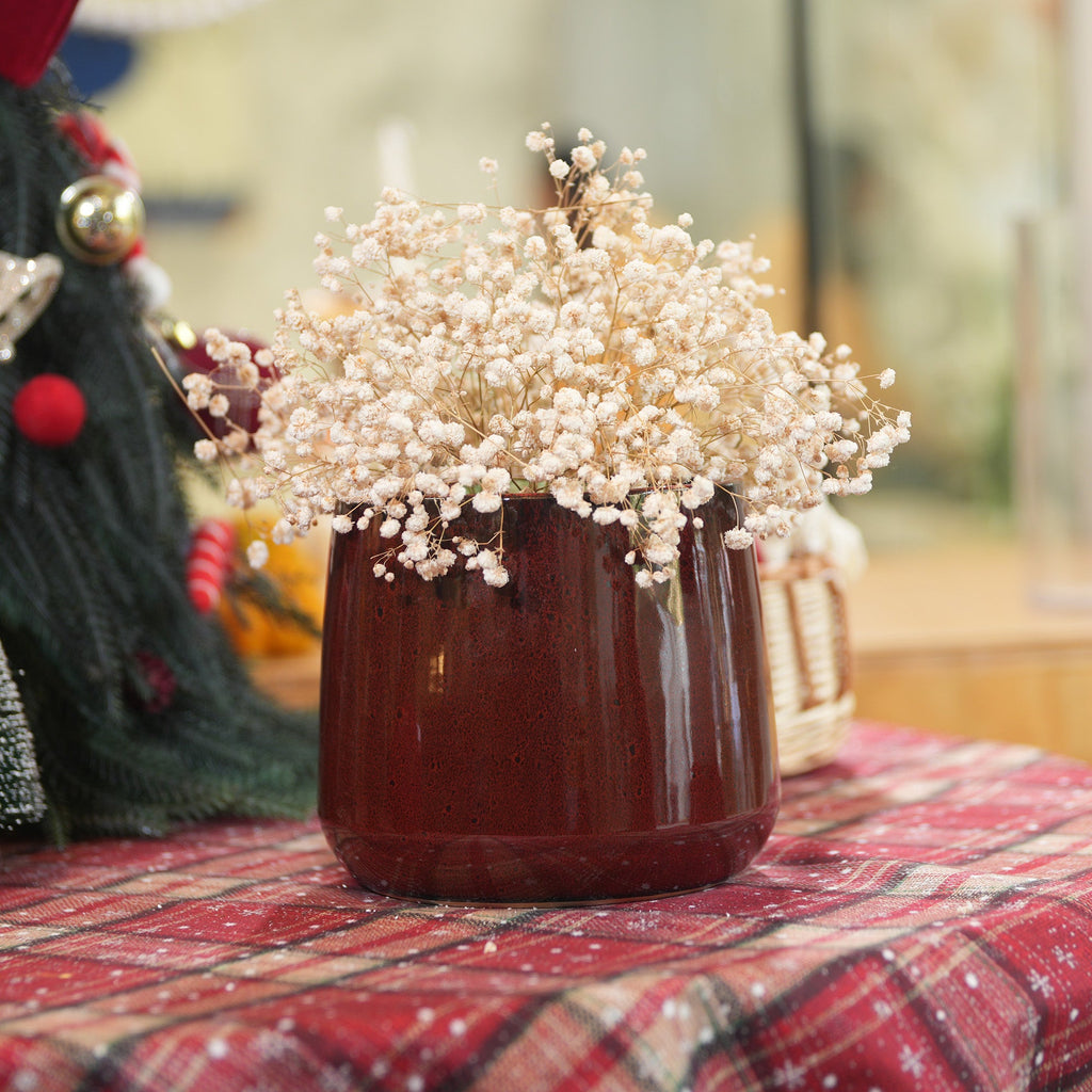 Decorative vase with white flowers on a red checkered surface