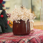 Decorative vase with white flowers on a red checkered surface