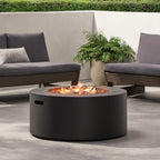 Round fire pit table with flames in an outdoor setting with gray chairs and a plant.