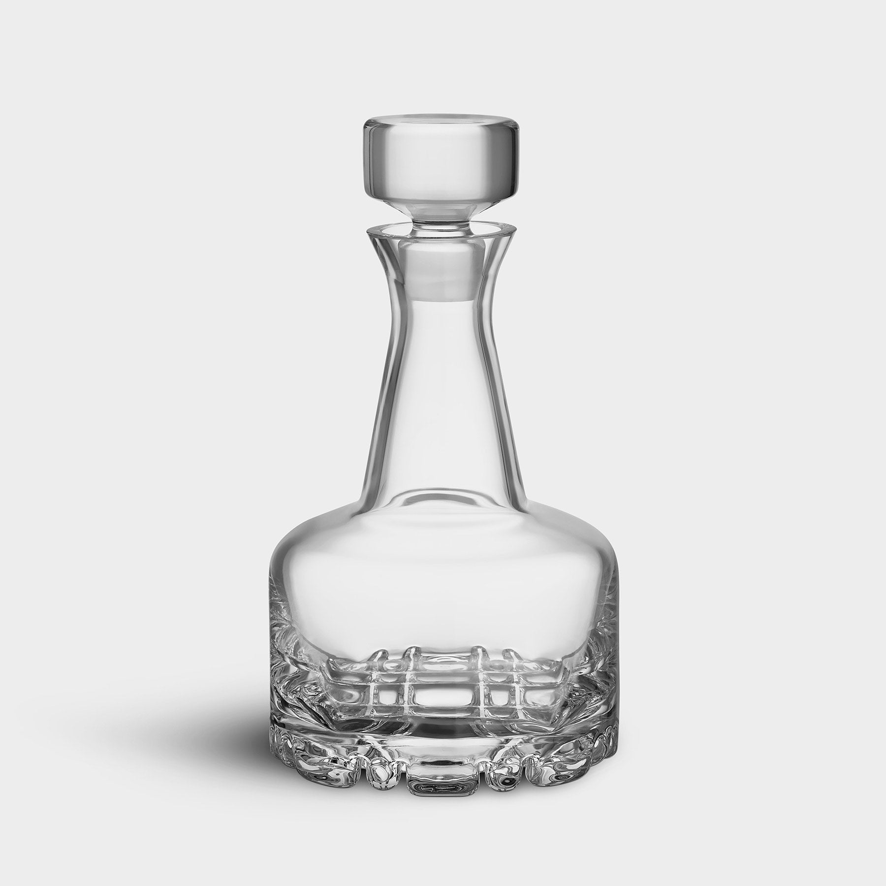 Clear glass decanter on a light gray background