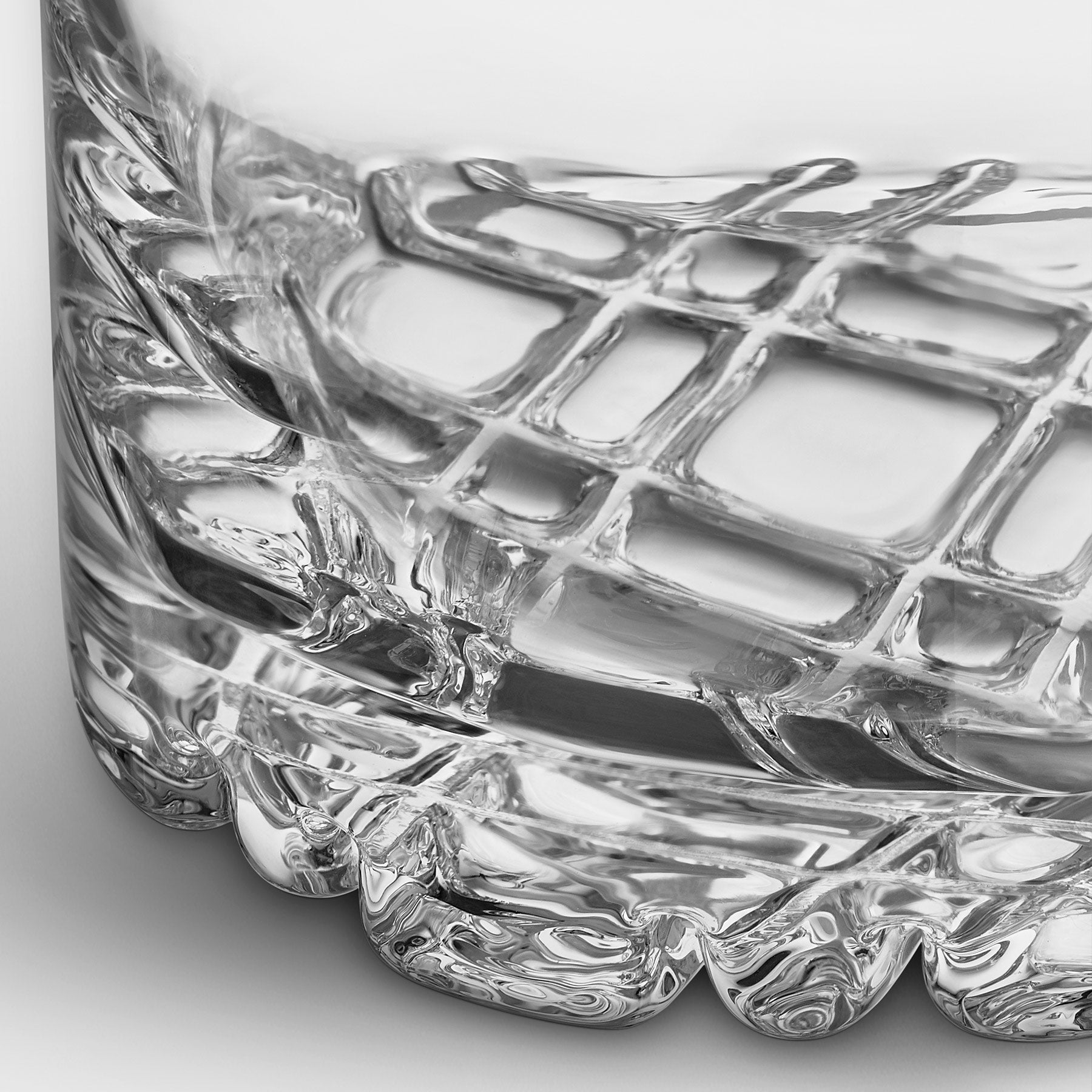 Close-up of a clear glass with geometric design on a white background
