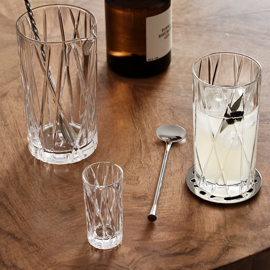 Clear glassware with ice and a bottle on a wooden surface