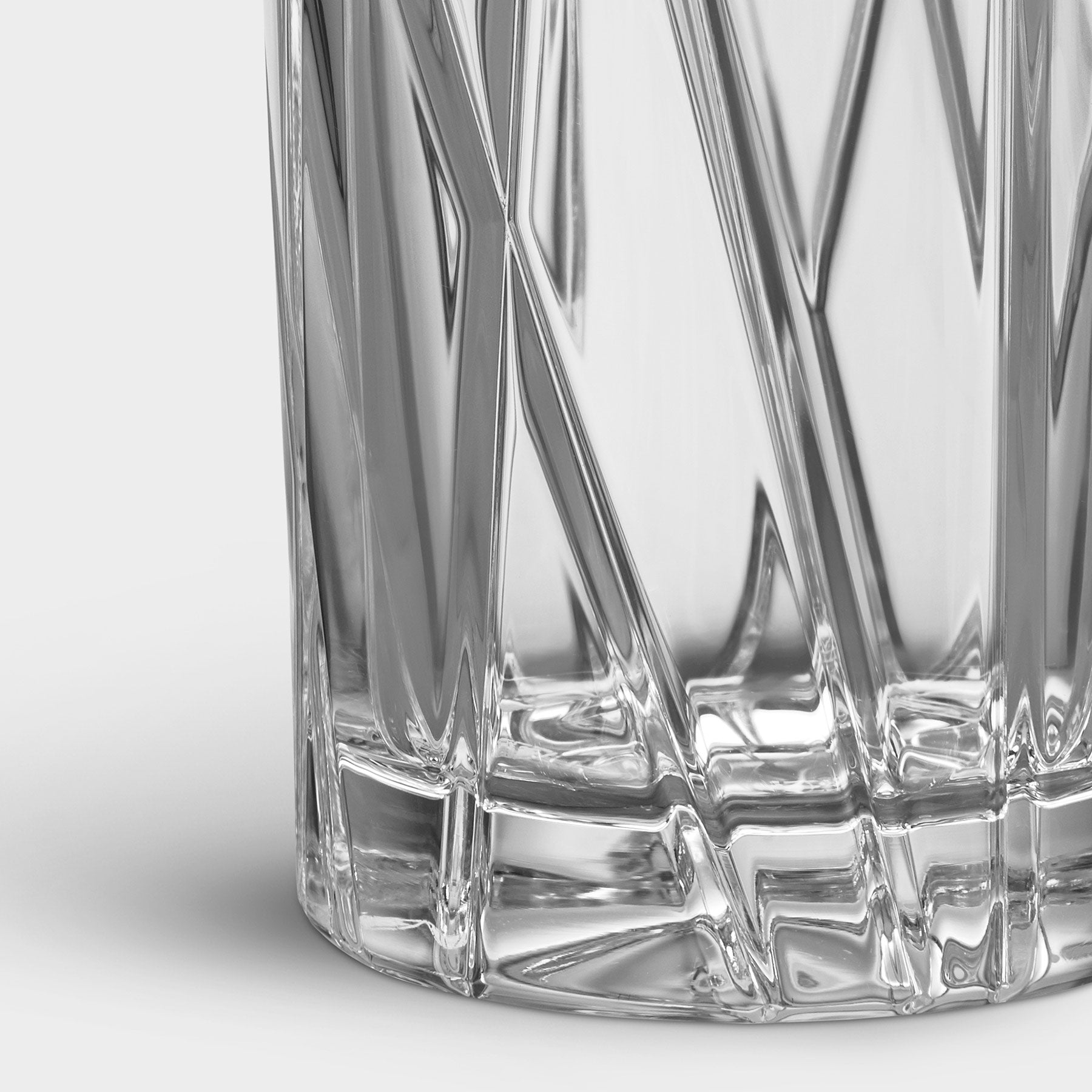 Close-up of a clear glass with geometric patterns on a white background