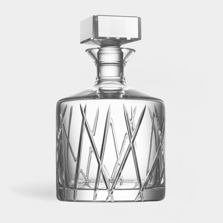 Clear glass decanter with a glass cap on a white background