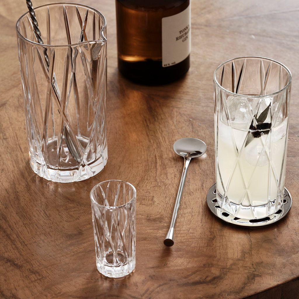 Clear glassware with ice and a bottle on a wooden surface