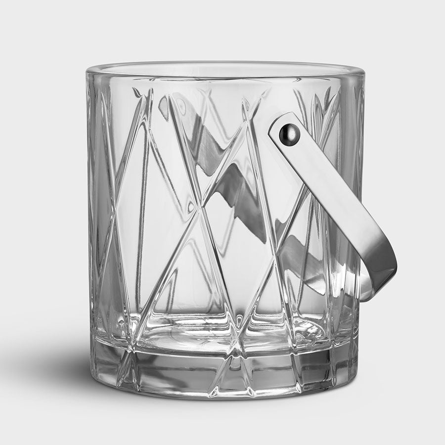 Clear glass ice bucket with a silver handle on a light gray background