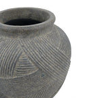 Close-up of a textured gray ceramic pot with carved geometric patterns, shown against a plain white background.