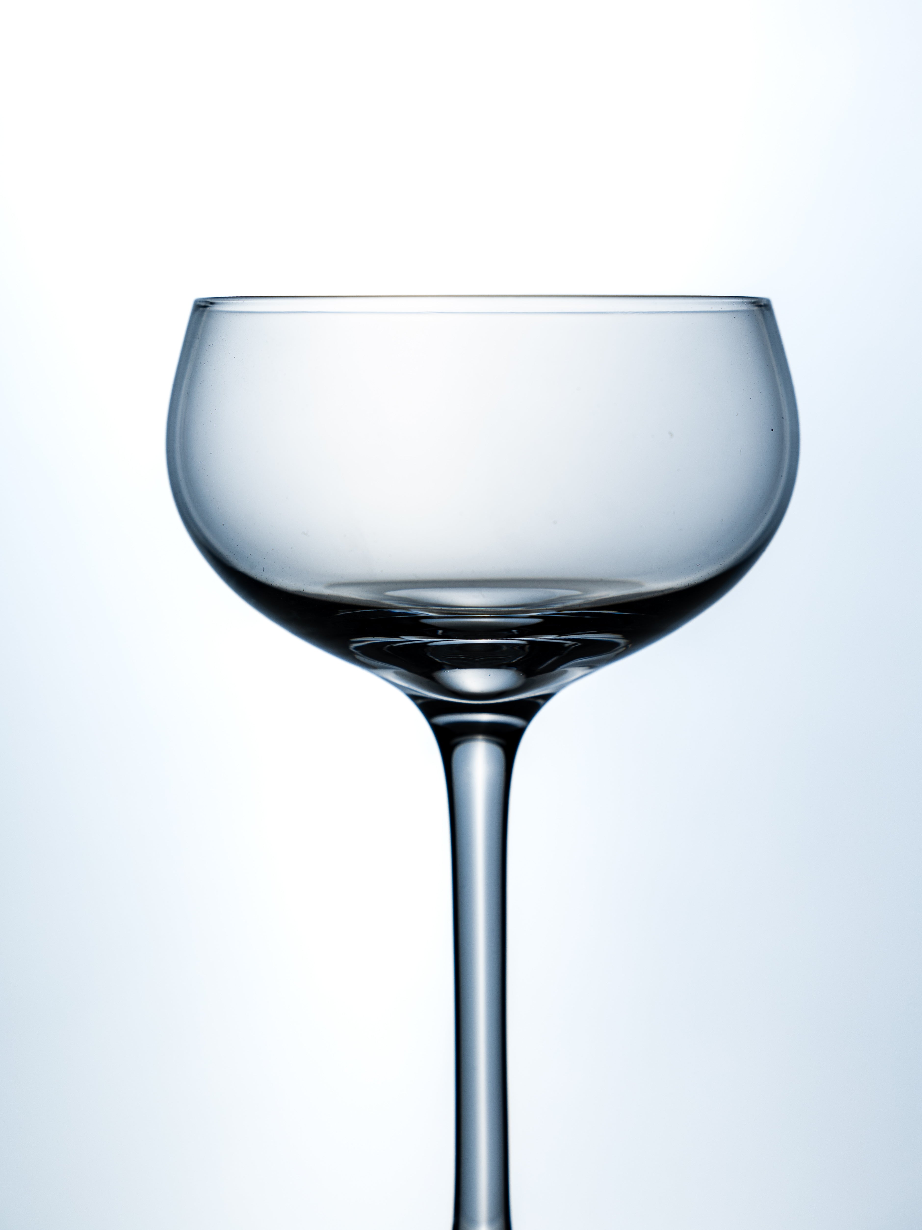 Clear glass wine glass on a light blue background