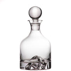 Clear glass decanter with a spherical stopper on a white background