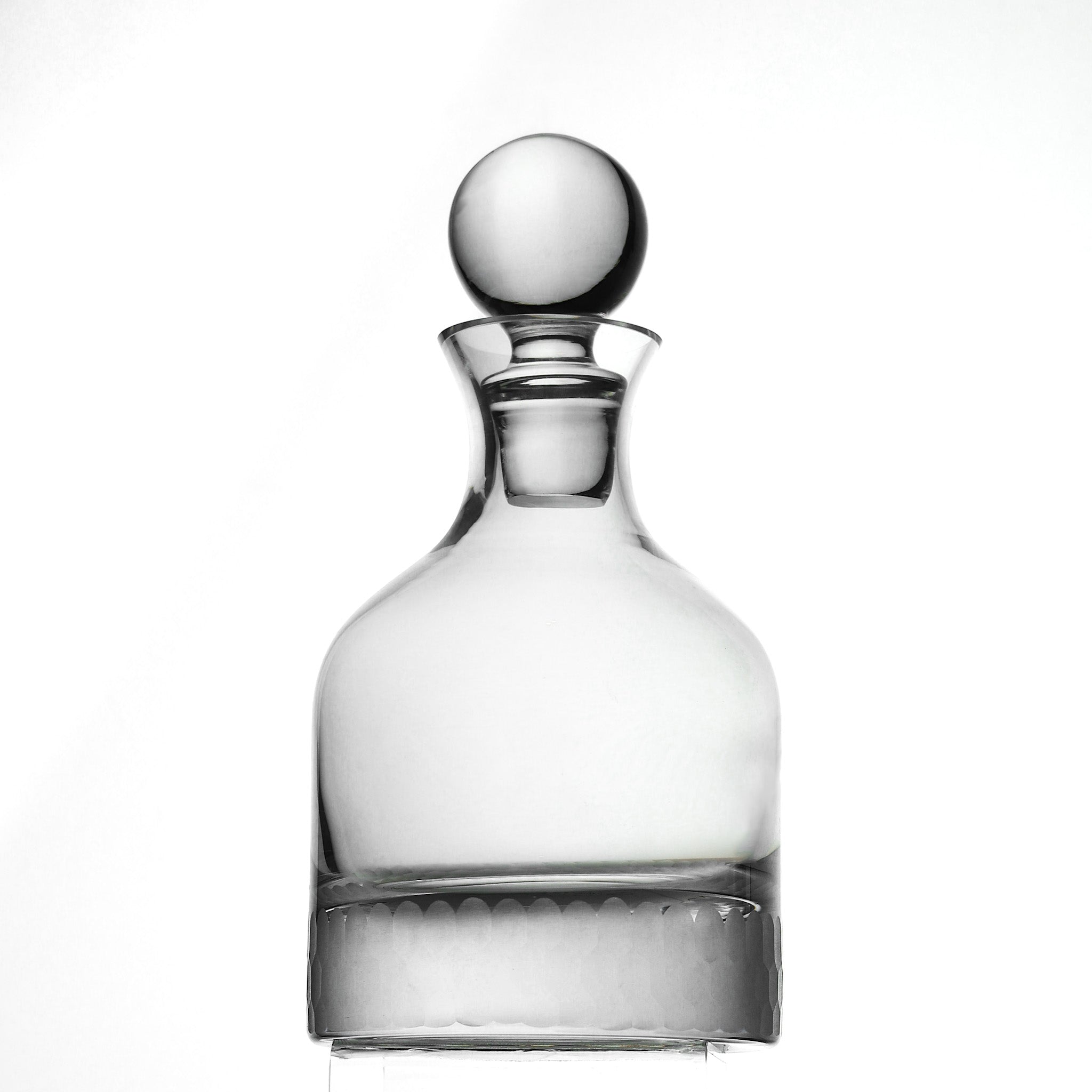 Clear glass decanter with honeycomb pattern and a spherical stopper on a white background