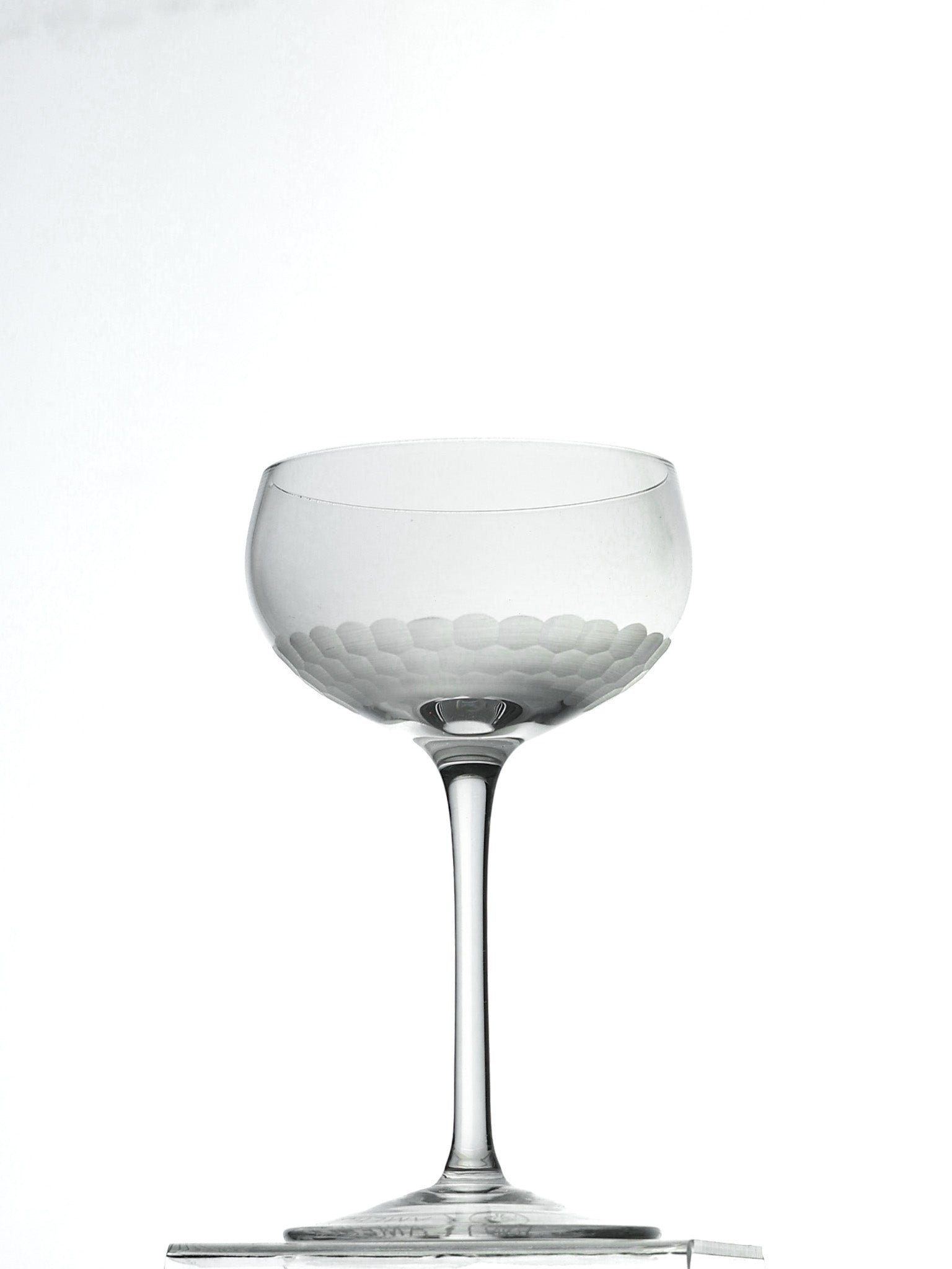 Clear glass cocktail coupe on a white background