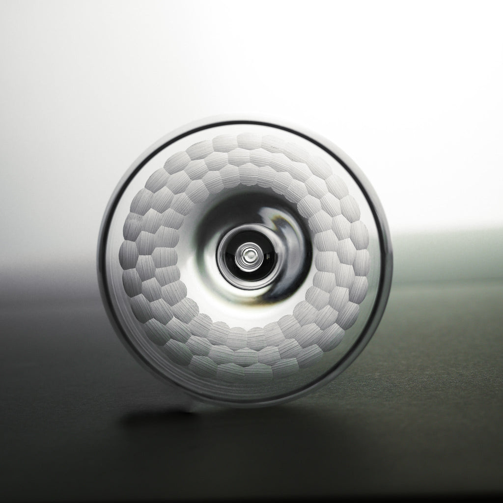 Close-up of a textured round glass with a central circular feature on a gradient background
