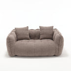 Brown sofa with quilted design and two cushions on a white background