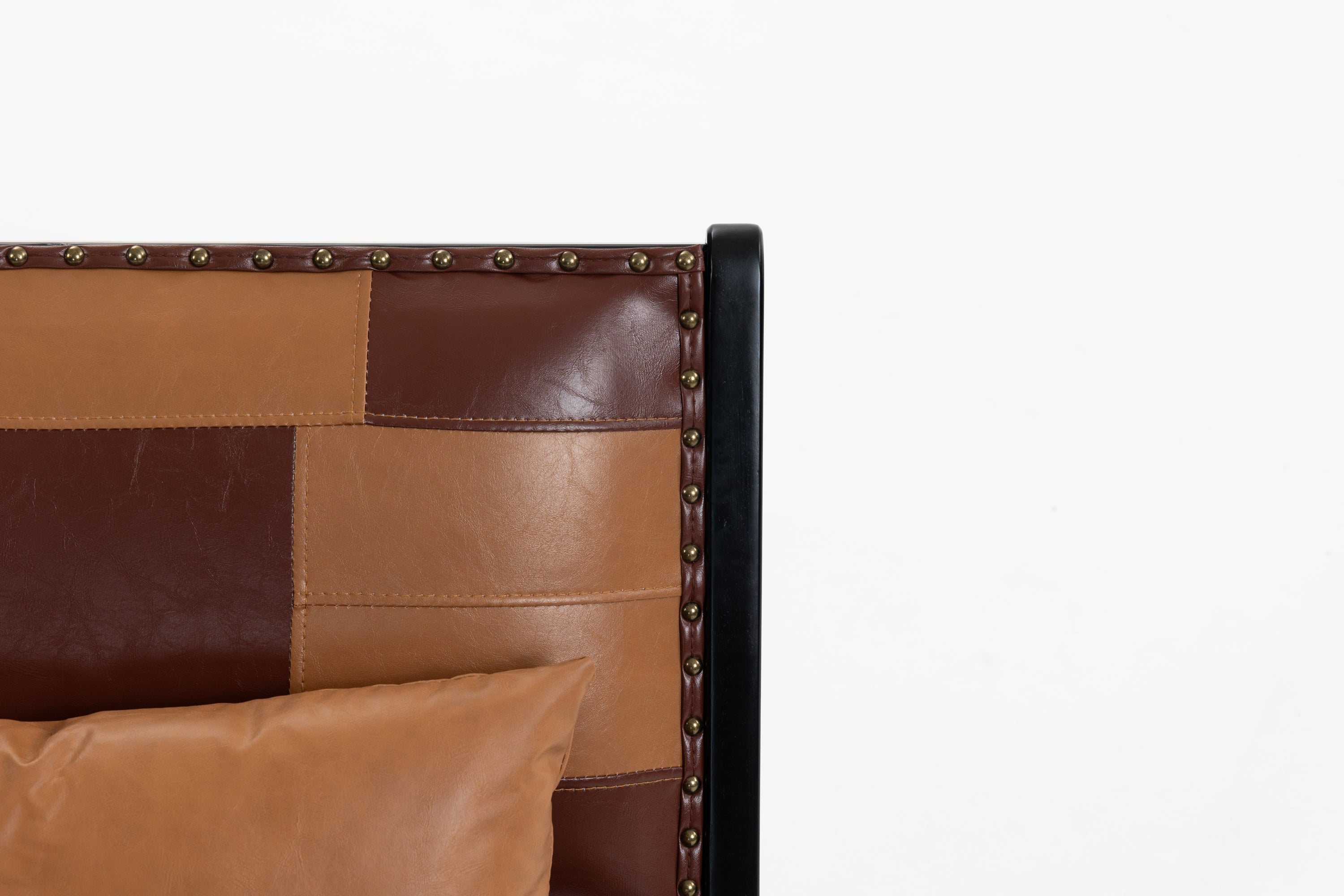 Brown leather headboard with patchwork design and decorative nails on a white background