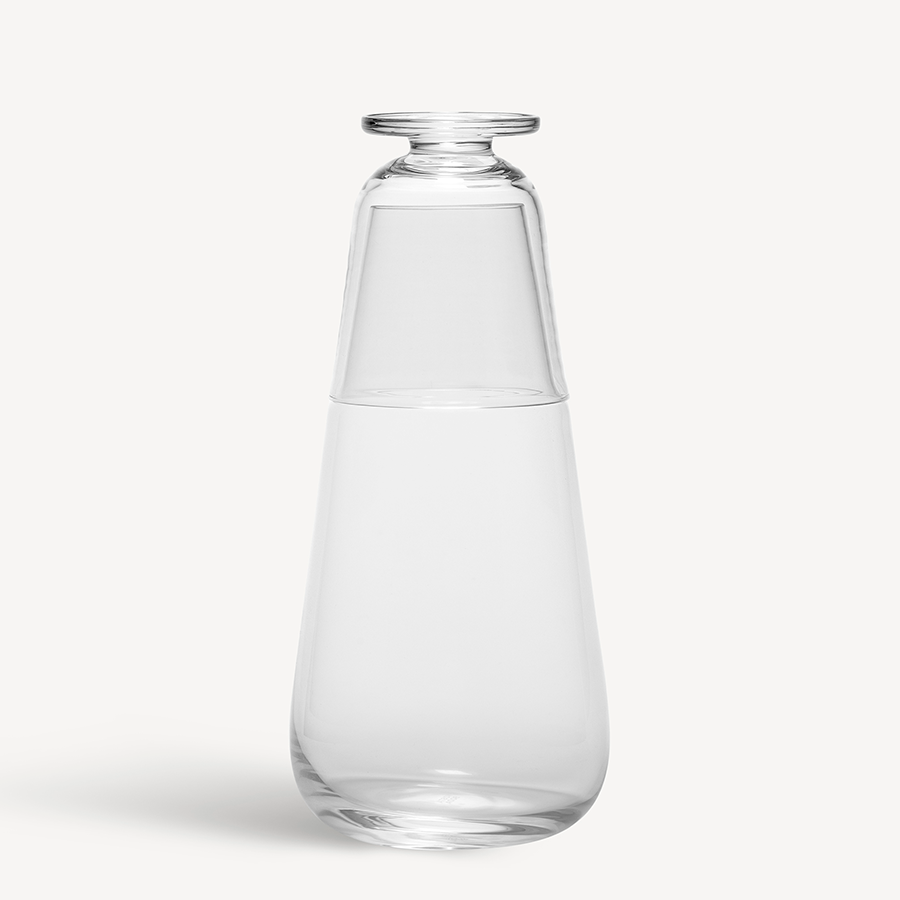Clear glass carafe with glass lid on a white background