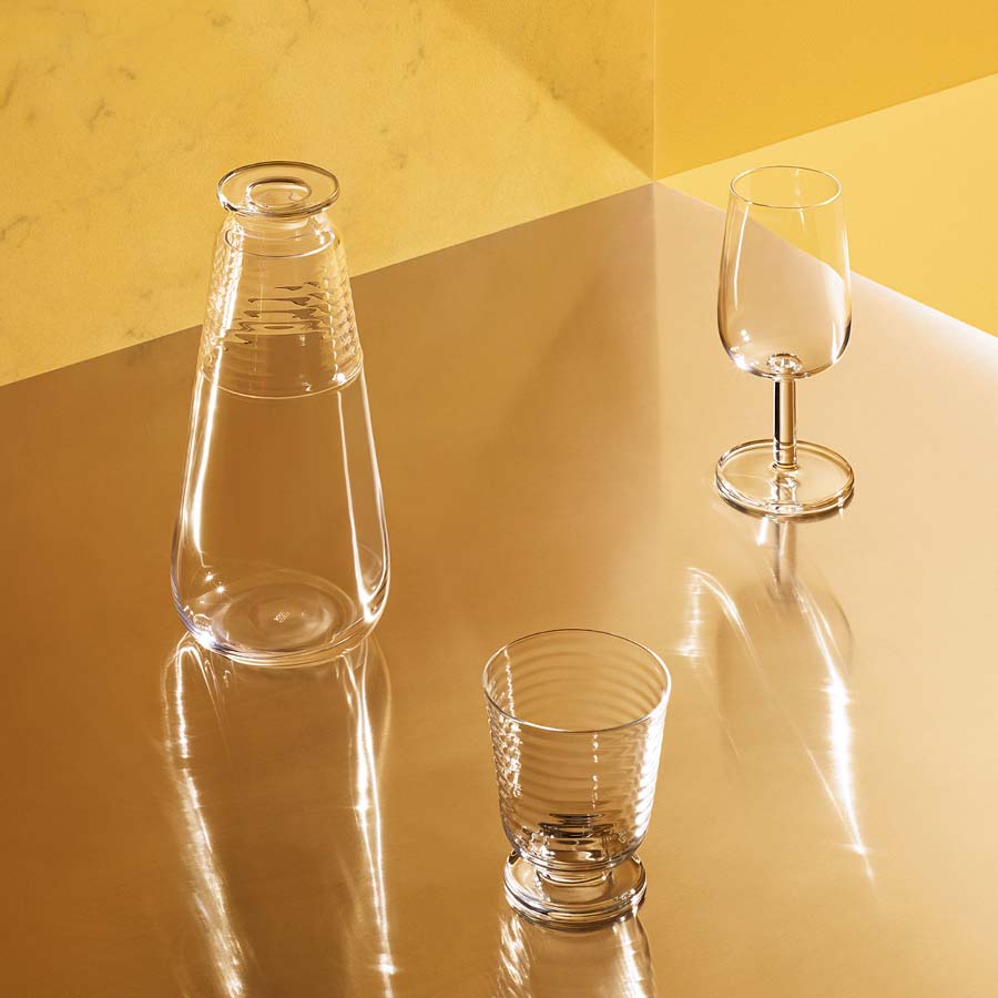 Three clear glassware items on a yellow and brown gradient surface