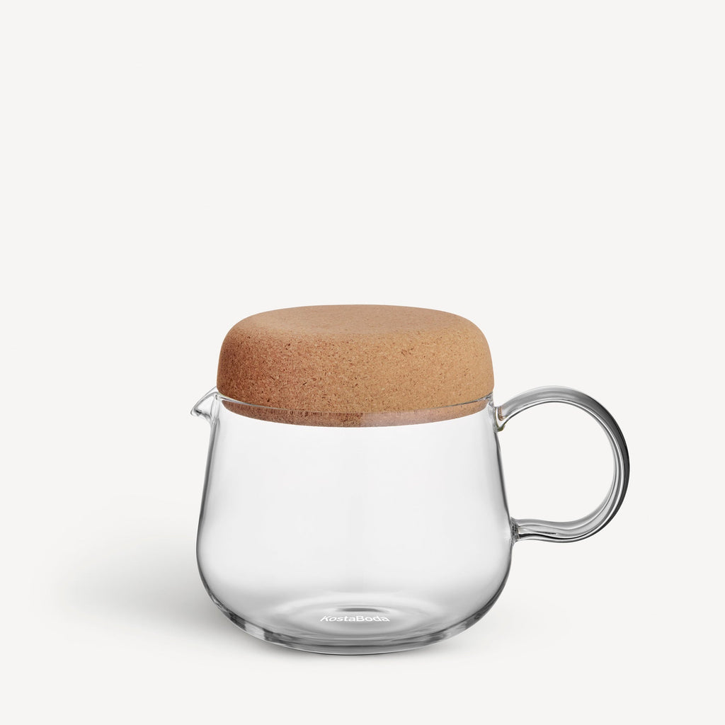 Clear glass teapot with a wooden lid on a white background