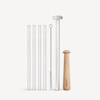 Set of reusable straws with a cleaning brush and holder on a white background
