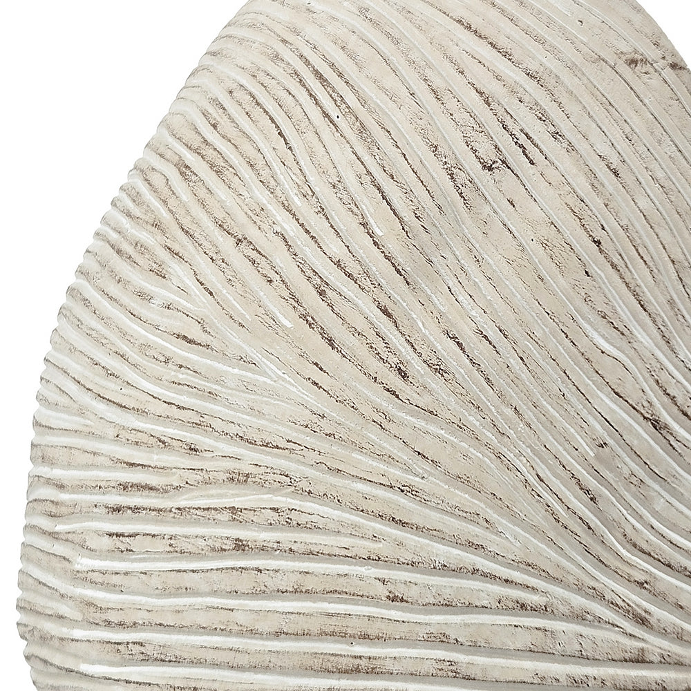 Close-up of a white ammonite fossil shaped vase with concentric circular patterns.