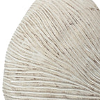 Close-up of a white ammonite fossil shaped vase with concentric circular patterns.