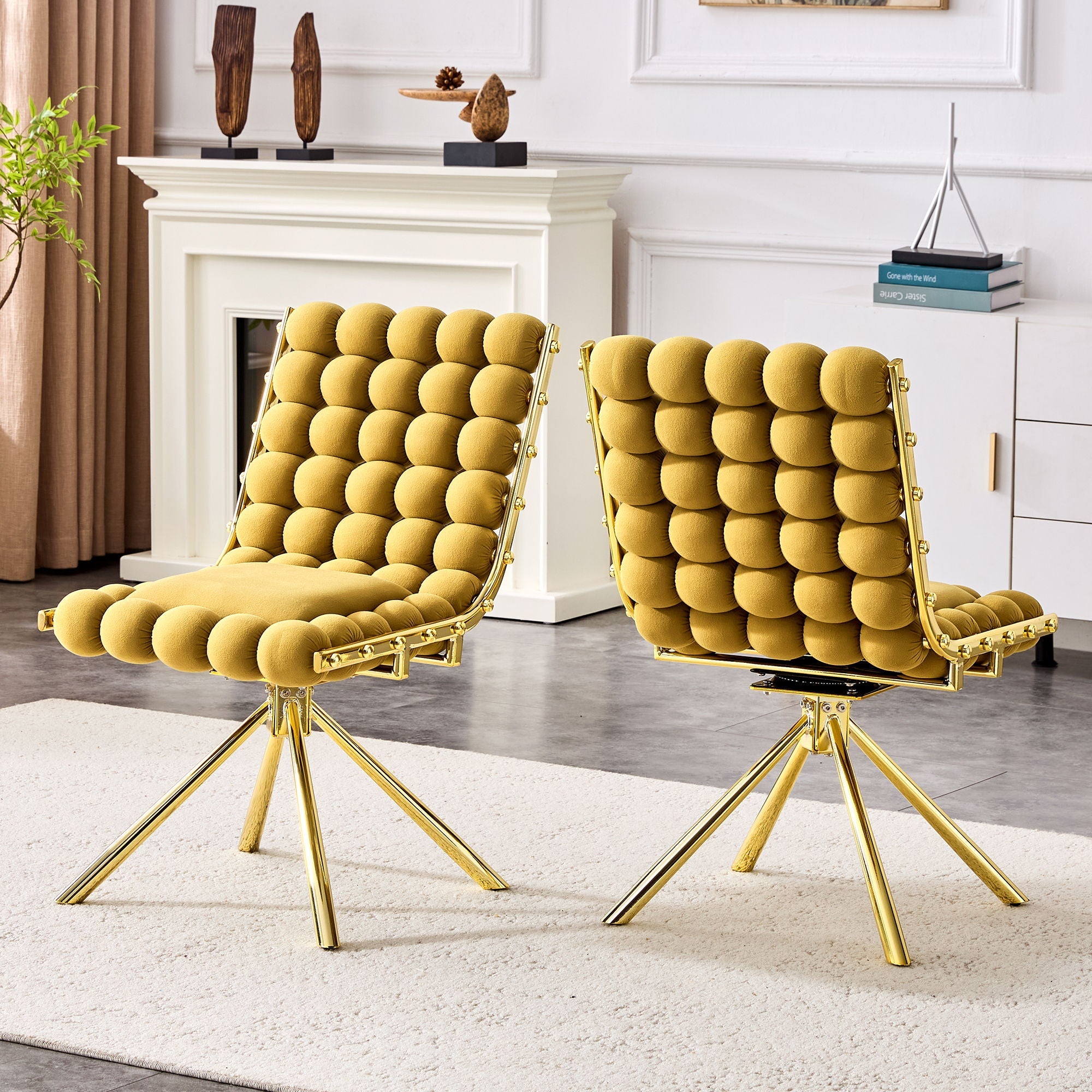 Two mustard yellow chairs with gold legs in a living room setting.