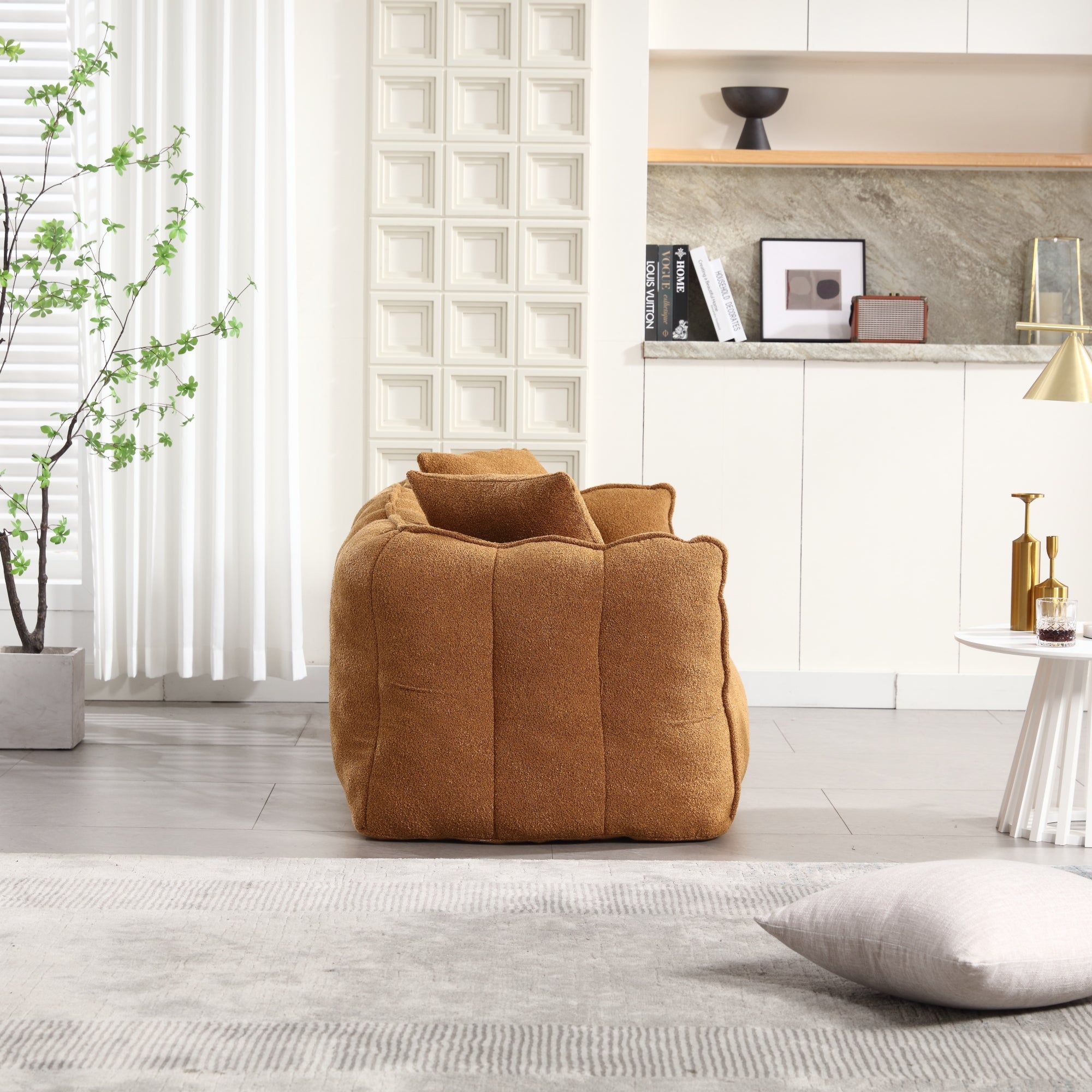 Brown bean bag sofa in a modern living room with a plant and shelves.