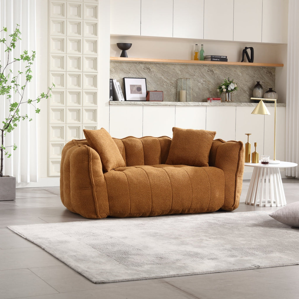 Brown sofa in a modern living room with a rug and decorative items.
