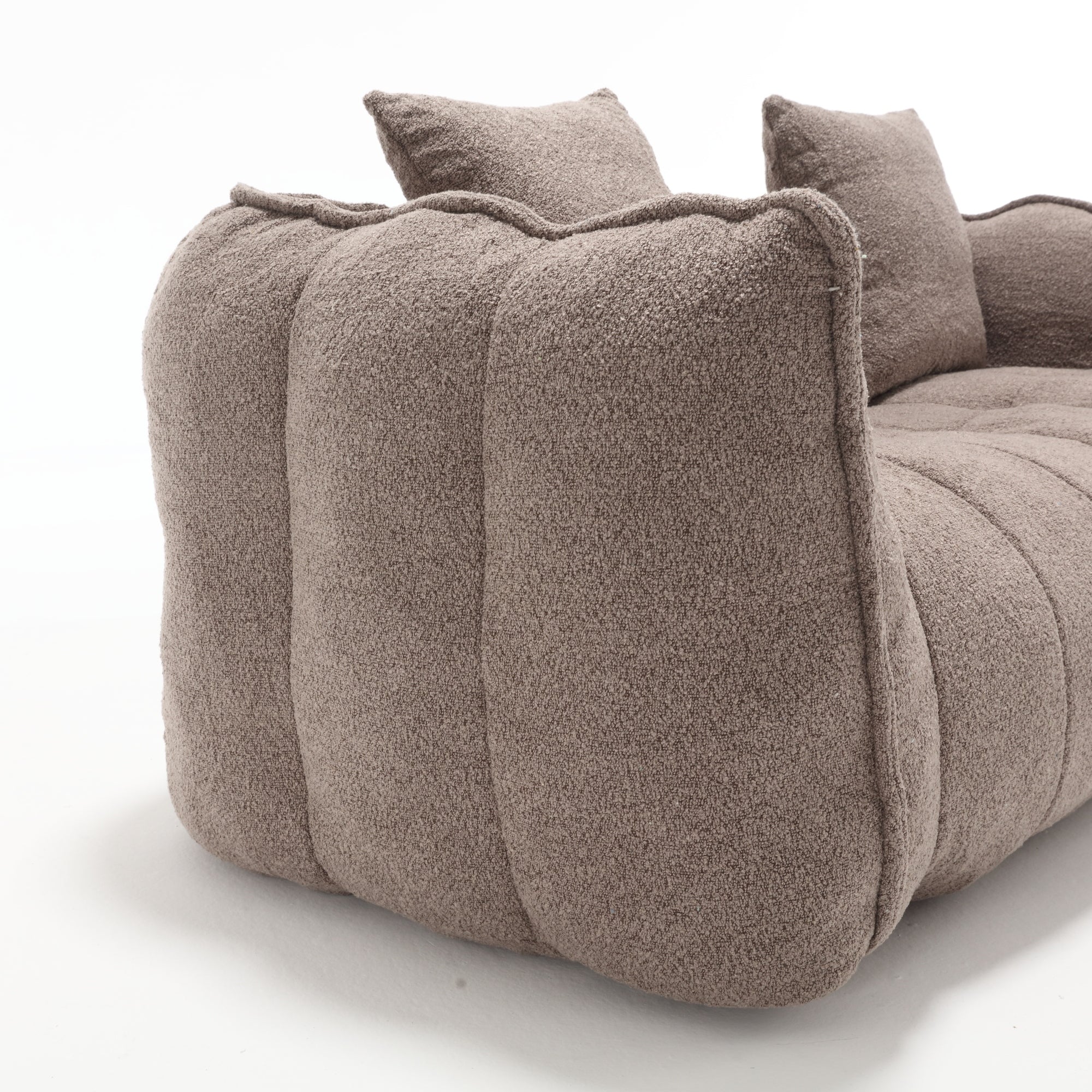 Brown textured sofa with cushions on a white background