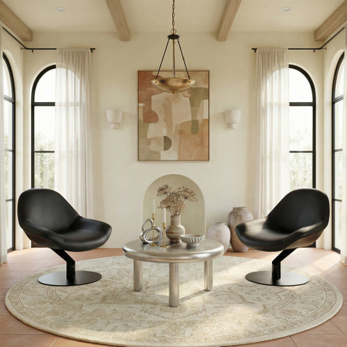 Modern living room with black chairs, round table, and abstract art on the wall.