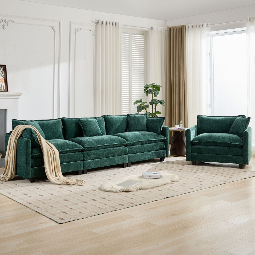 Green sofa and armchair in a living room with light wood flooring and white walls.