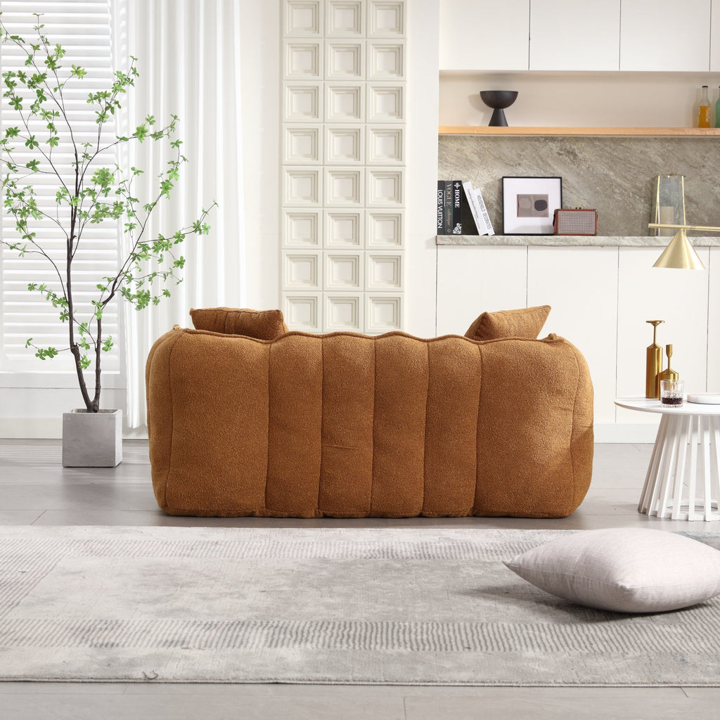 Brown sofa in a modern living room with a plant and decorative items.