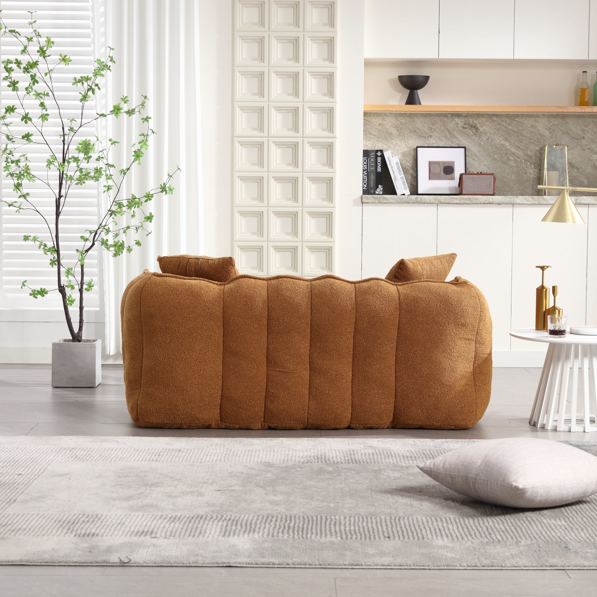 Brown sofa in a modern living room with a plant and decorative items.