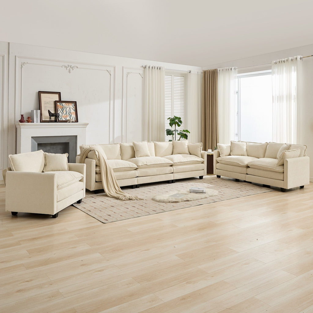 Beige living room furniture set in a bright room with large windows.