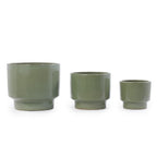Three ceramic planters in a matching muted sage green glaze, arranged by size from left to right on a plain white background.
