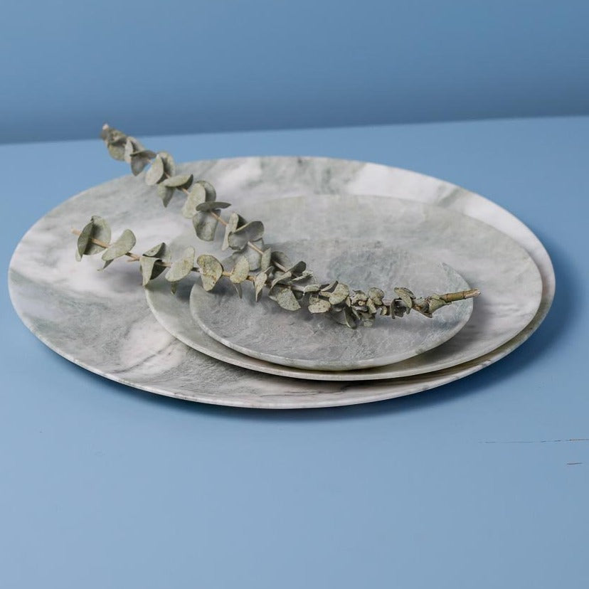 Set of marble plates with a branch on a blue background