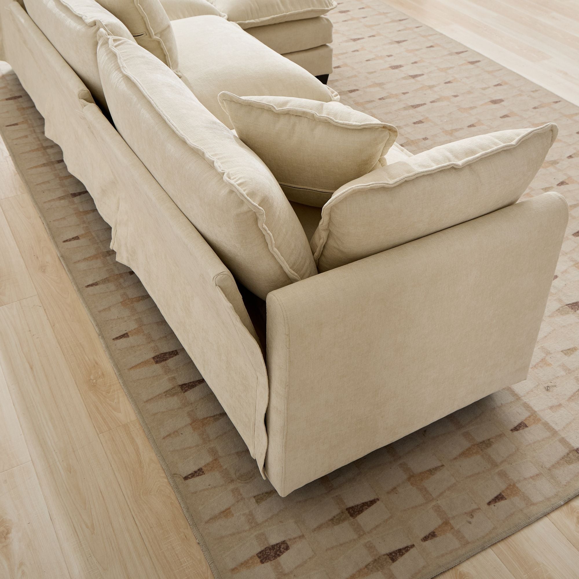 Beige sofa with cushions on a textured floor