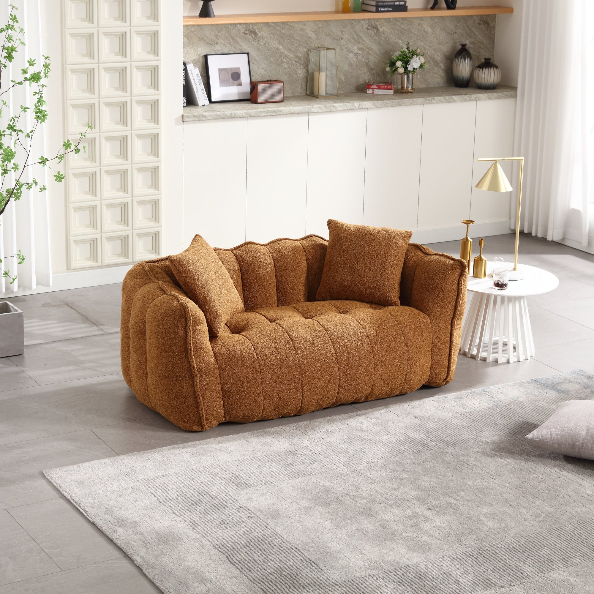 Brown sofa in a modern living room with a rug and decorative items.