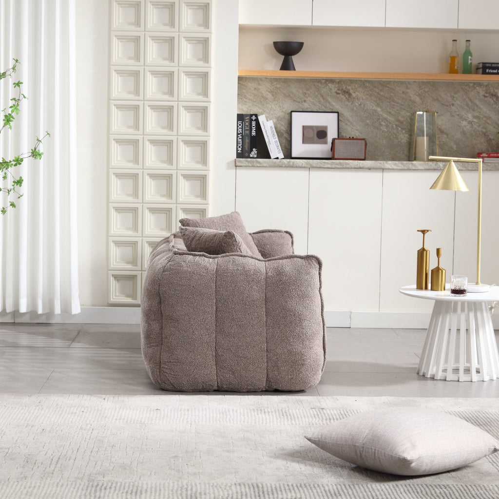 Gray bean bag chair in a modern living room with a shelf and decor items.
