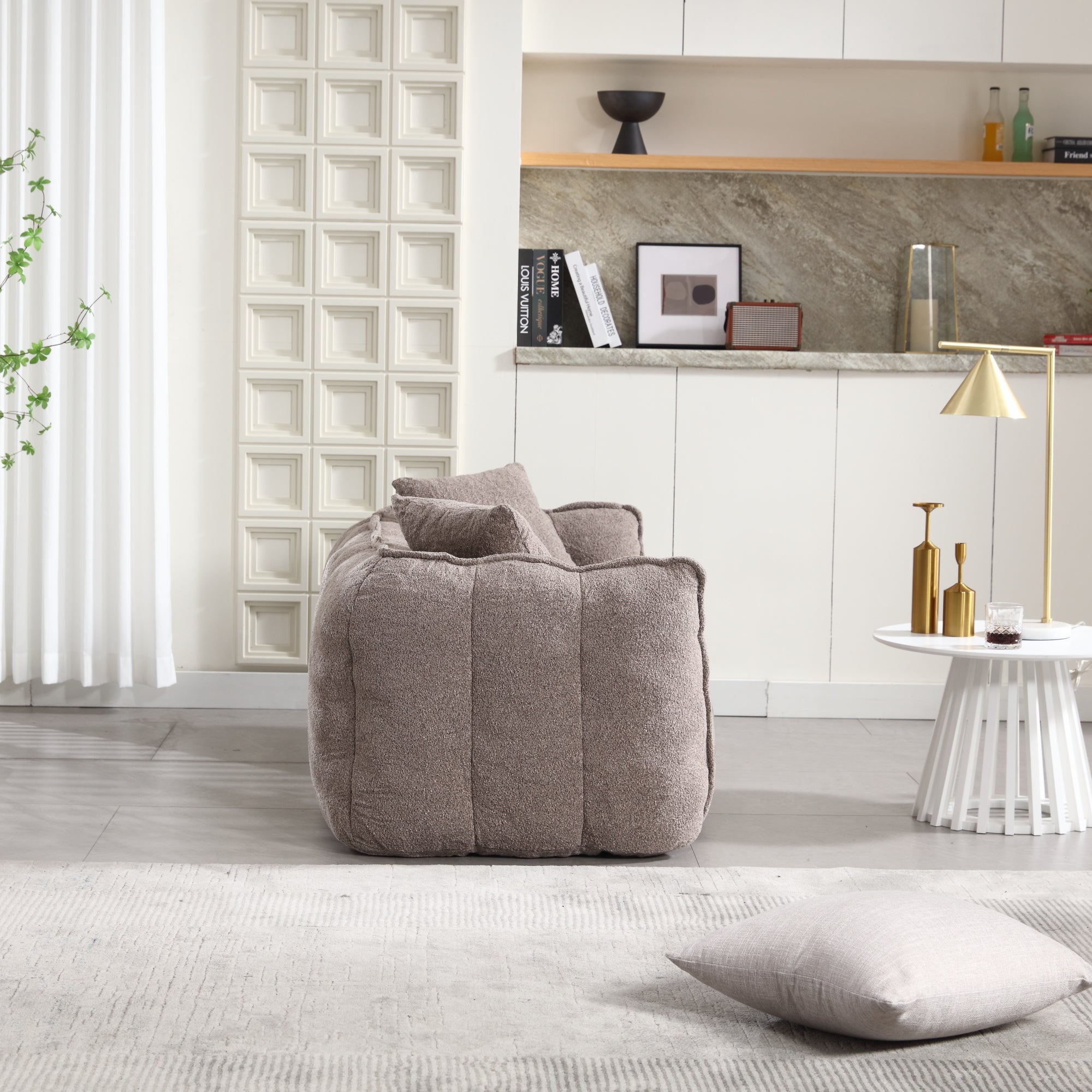 Gray bean bag chair in a modern living room with a shelf and decor items.