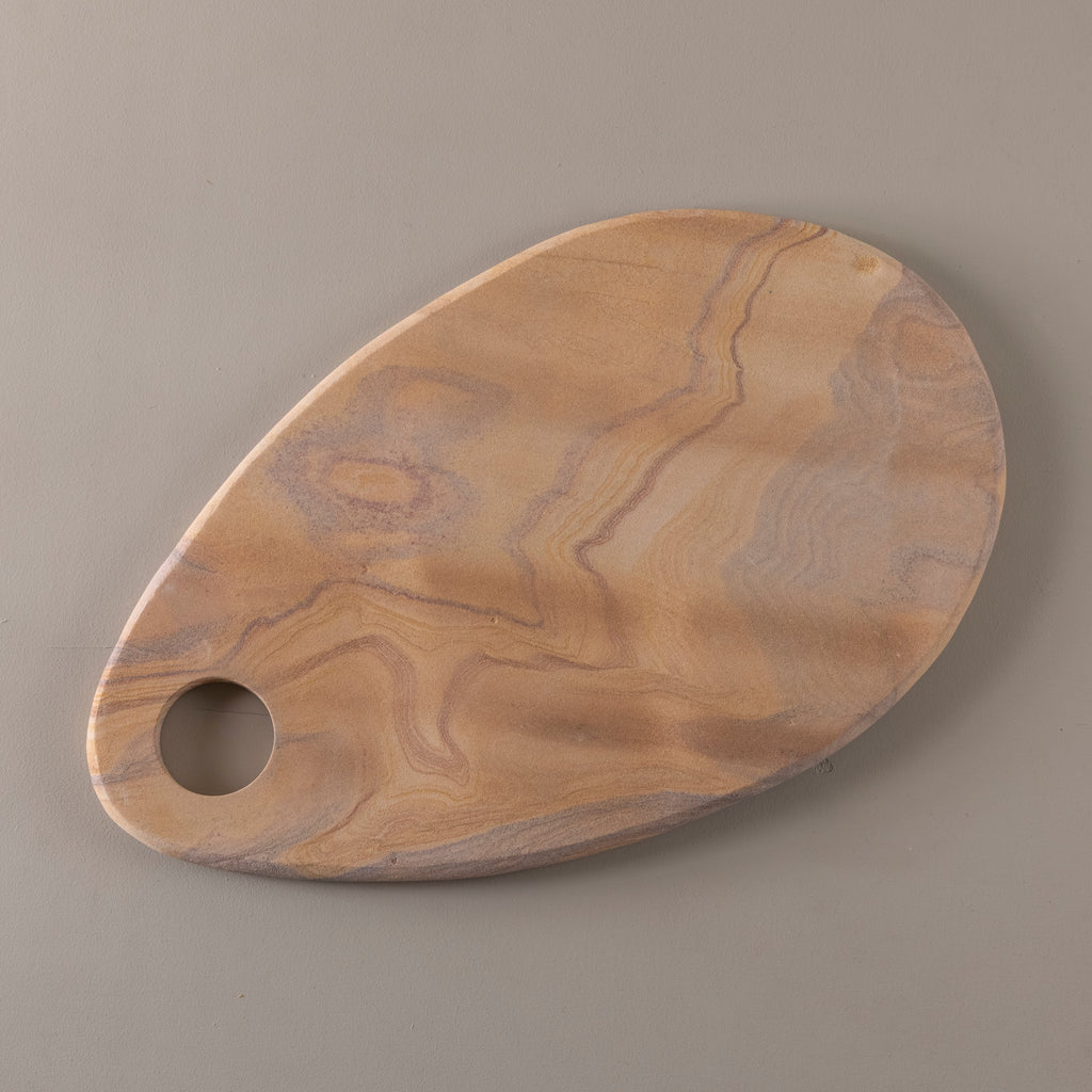 Wooden cutting board with a hole on a gray background