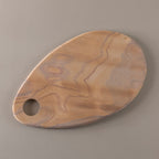 Wooden cutting board with a hole on a gray background
